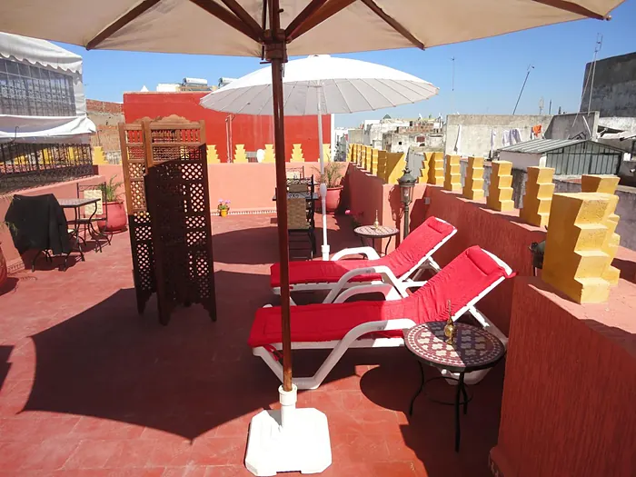 La terrasse, parasols et transats rouges